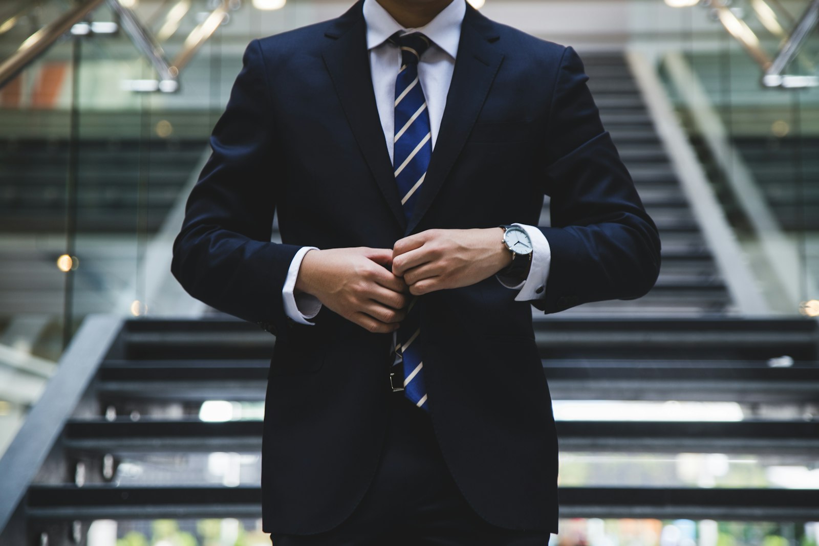 Hombre abotonándose la chaqueta de un traje formal
